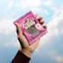 Hand holding a Fields Good focus cookie package against a blue sky background