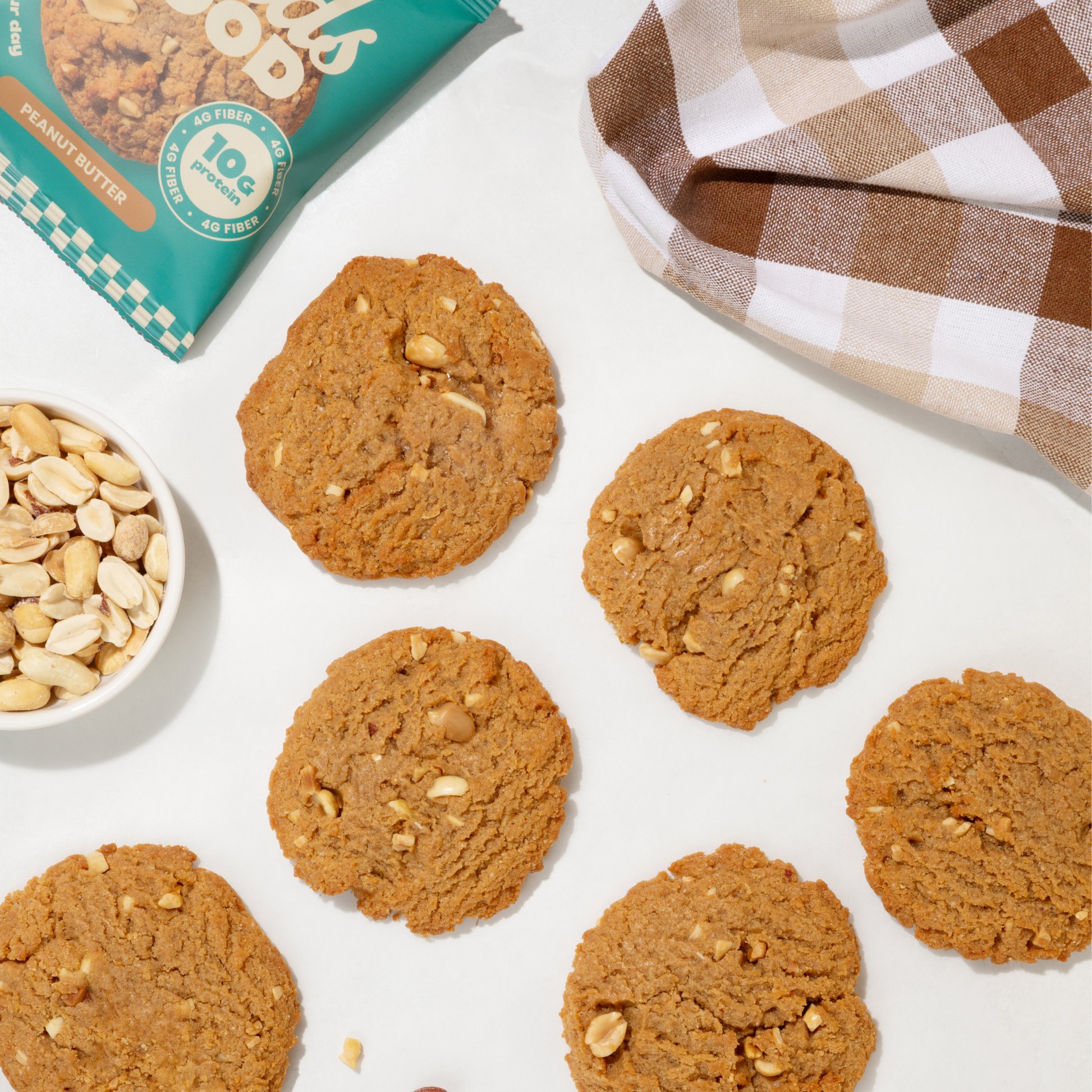 Fields Good Peanut butter cookies with a bowl of peanuts and a package on a white surface.