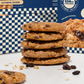 Stack of oatmeal raisin cookies with a blue and white checkered box in the background